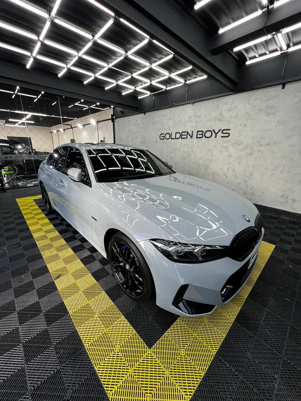 BMW branco na Golden Boys Detailers, sob as luzes do espaço de estética automotiva