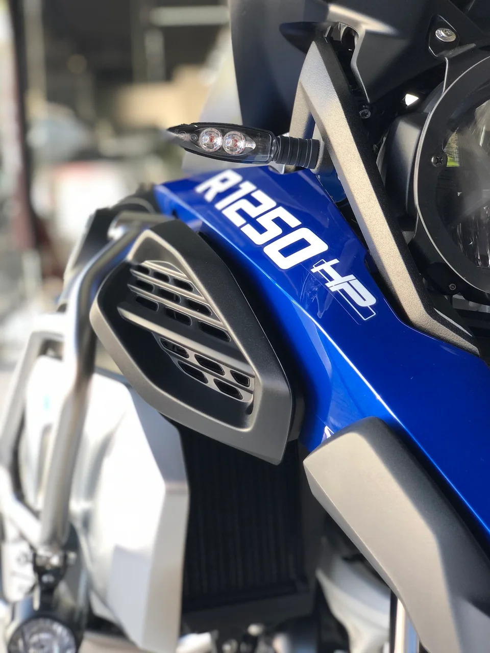 Detalhe do tanque e da carenagem de uma moto BMW azul e branca